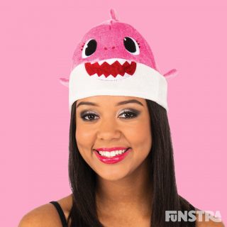 Anyone can dress up as Mummy Shark with this unisex hat that will fit most adults. The pink Mummy Shark plush beanie style hat features felt teeth and eyes with 3D mini fins attached at the sides and mini dorsal fin on top.