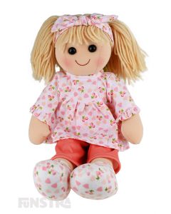 Chloe is an adorable doll with a soft cloth body and blonde hair held back with a headband and wears a peach printed top and peach trousers.
