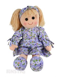 Lily is an lovely doll with a soft cloth body and blonde hair tied back in pigtails and wears a lavender floral printed dress and a matching headband.