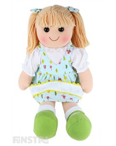 Pippa is a summery doll with a soft cloth body and blonde hair tied back in pigtails with bows and wears a tropical printed dress and embellished with ribbon over a white blouse.