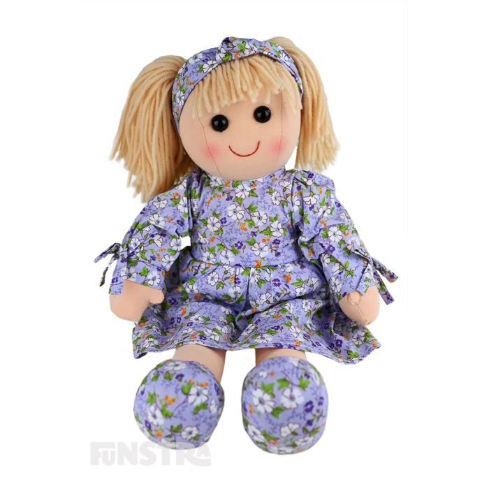 Lily is an lovely doll with a soft cloth body and blonde hair tied back in pigtails and wears a lavender floral printed dress and a matching headband.