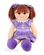 Penny is an adorable doll with a soft cloth body and brown hair tied in pigtails with purple plaid bows and wears a matching purple tartan dress with a purple ribbon around her waist.