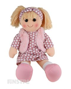 Trixie is a fashionable doll with a soft cloth body and blonde hair tied back in pigtails and wears a spotted printed dress and pink faux fur jacket and a matching headband.