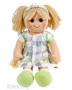 Ava is an precious doll with a soft cloth body with blonde hair tied in pigtails with a headband and wears a pastel plaid print dress.