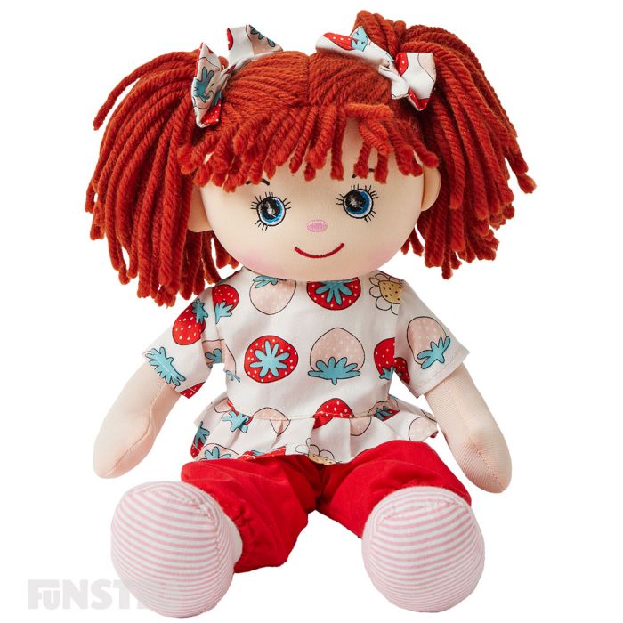 Dottie is a sweet rag doll with a soft cloth body and red hair tied in pigtails and wears a berry sweet top featuring a strawberry print on it with red pants and loves baking and running in the park. Dottie is a sweet rag doll with a soft cloth body and red hair tied in pigtails and wears a berry sweet top featuring a strawberry print on it with red pants and loves baking and running in the park.